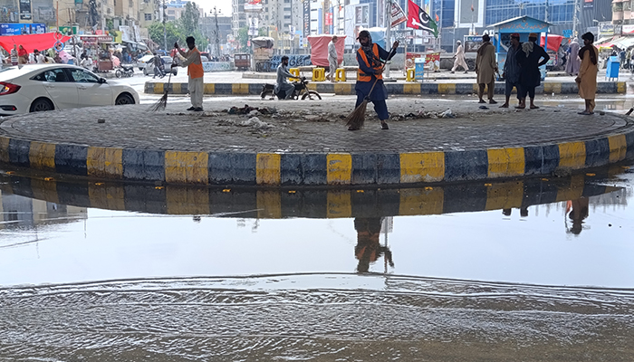 Sweepers clear a Karachi road a day after heavy rains battered the city, August 20, 2025. — Geo.tv