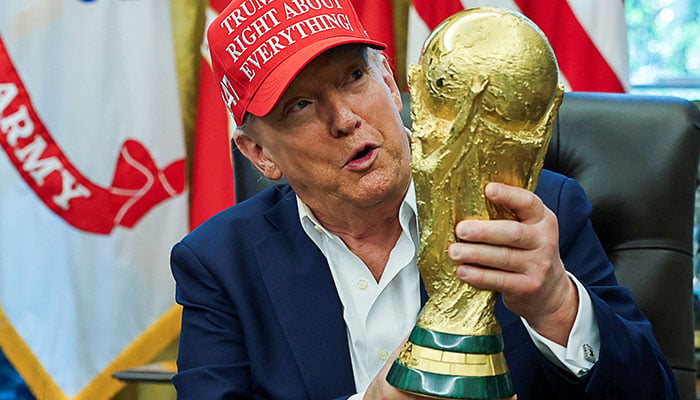 US President Donald Trump wears a Trump Was Right About Everything! hat while holding the FIFA World Cup Trophy, as he makes an announcement on the 2026 FIFA World Cup, in the Oval Office at the White House in Washington, DC, US, August 22, 2025. — Reuters