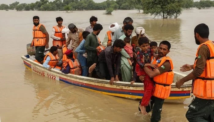Rescue workers help to evacuate flood-affected people from their flood-hit homes following heavy monsoon rains in the Rajanpur district of Punjab. — AFP/File