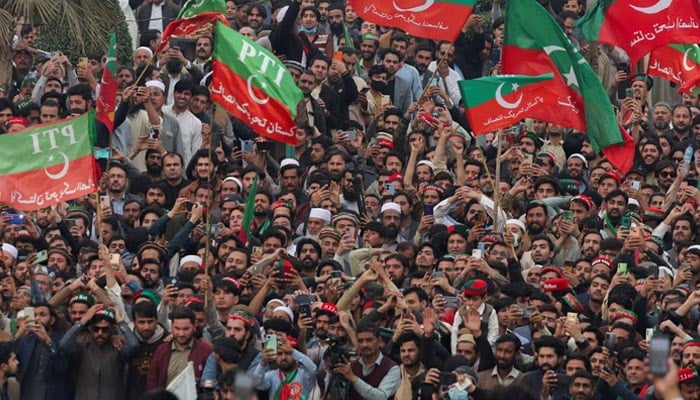 Supporters of Pakistan Tehreek-e-Insaf (PTI) wave flags as they protest in Peshawar on February 17, 2024. — Reuters