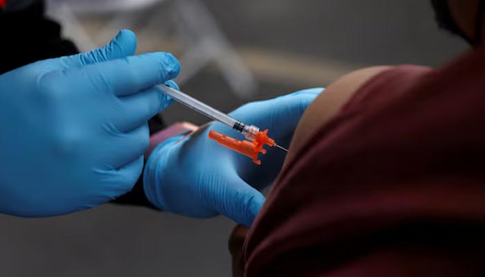 A health care administer gives the vaccine dose to a person in Los Angeles, California, US, January 29, 2022. Reuters