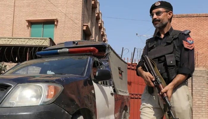 A police officer stands guard near his vehicle in Quetta. — Reuters/File