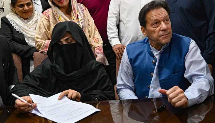 PTI founder Imran Khan along with his wife Bushra Bibi looks on as he signs surety bonds for bail in various cases at a registrar office in Lahore on July 17, 2023. — AFP