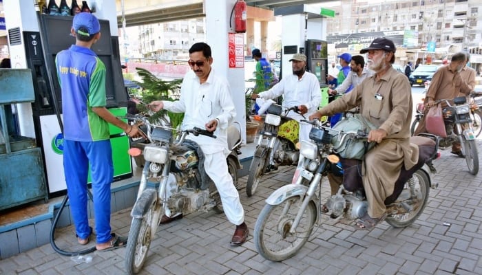Motorcyclists waiting for their turn to fill fuel in their bikes at a petrol pump in Hyderabad on May 16, 2024. —APP