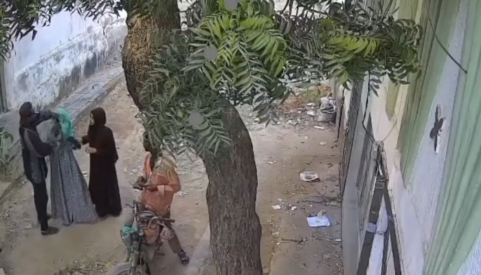 The photograph shows two men robbing women in Karachis Orangi area.— Screengrab/GeoNews