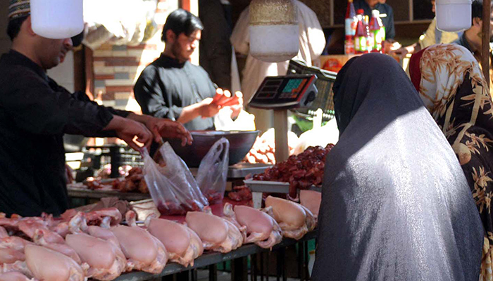 A woman buys chicken in Quetta, on March 1, 2025. — INP