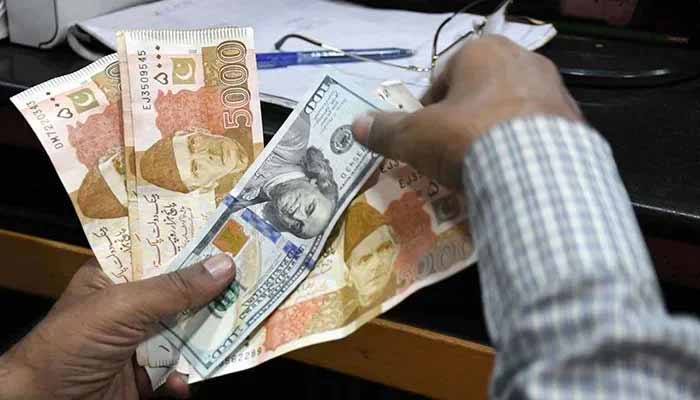 A foreign currency changer counts Pakistani rupee notes at a shop in Karachi, on March 2, 2023. — Online