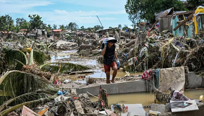 A resident walks among badly damaged houses in the aftermath of Typhoon Kalmaegi in the Philippines Cebu province. — AFP