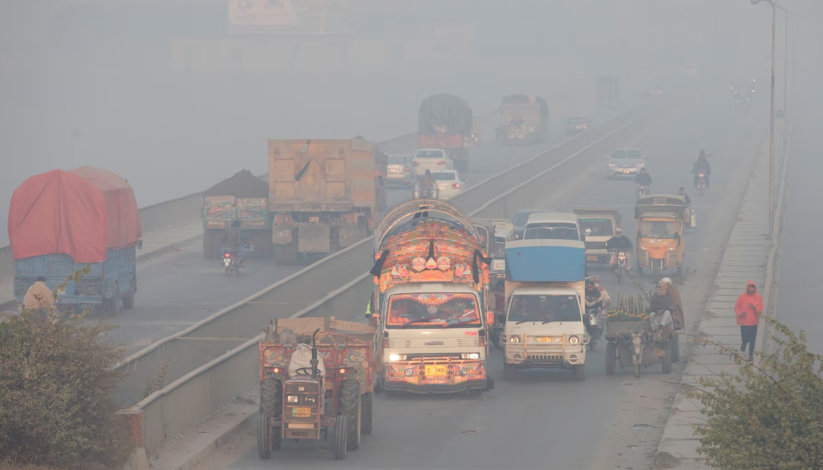 Vehicles move amid dense smog in Lahore on November 24, 2021. — Reuters