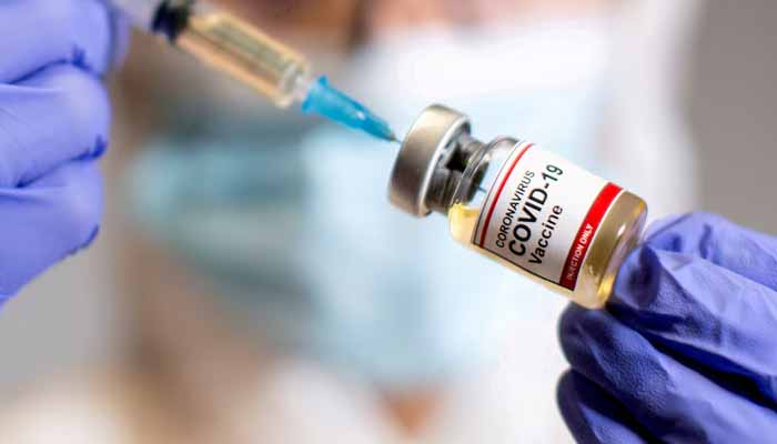 A woman holds a small bottle labelled with a Coronavirus COVID-19 Vaccine sticker and a medical syringe in this illustration taken October 30, 2020.— Reuters