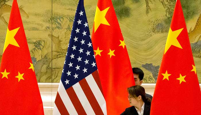 Staffers adjust US and Chinese flags at the Diaoyutai State Guesthouse in Beijing, China. — Reuters/File