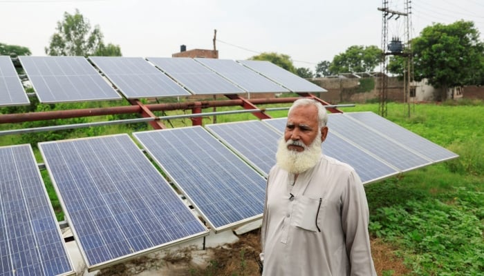 Mohammad Naseem, a farmer, stands beside his solar panels, installed to run a tube well, in Muridke, Sheikhupura District, on August 12, 2025. — Reuters
