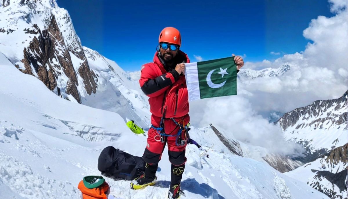 Mountaineer Sirbaz Khan displays Pakistans flag after successfully summiting Mount Kangchenjunga in Nepal without supplemental oxygen. — Instagram/@sirbazkhan_mission14