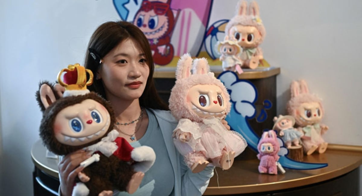 A woman poses with Labubu (L) and Mokoko characters in an exhibition hall as they visit Pop Mart theme park Pop Land in Beijing, China on June 18, 2025. — AFP