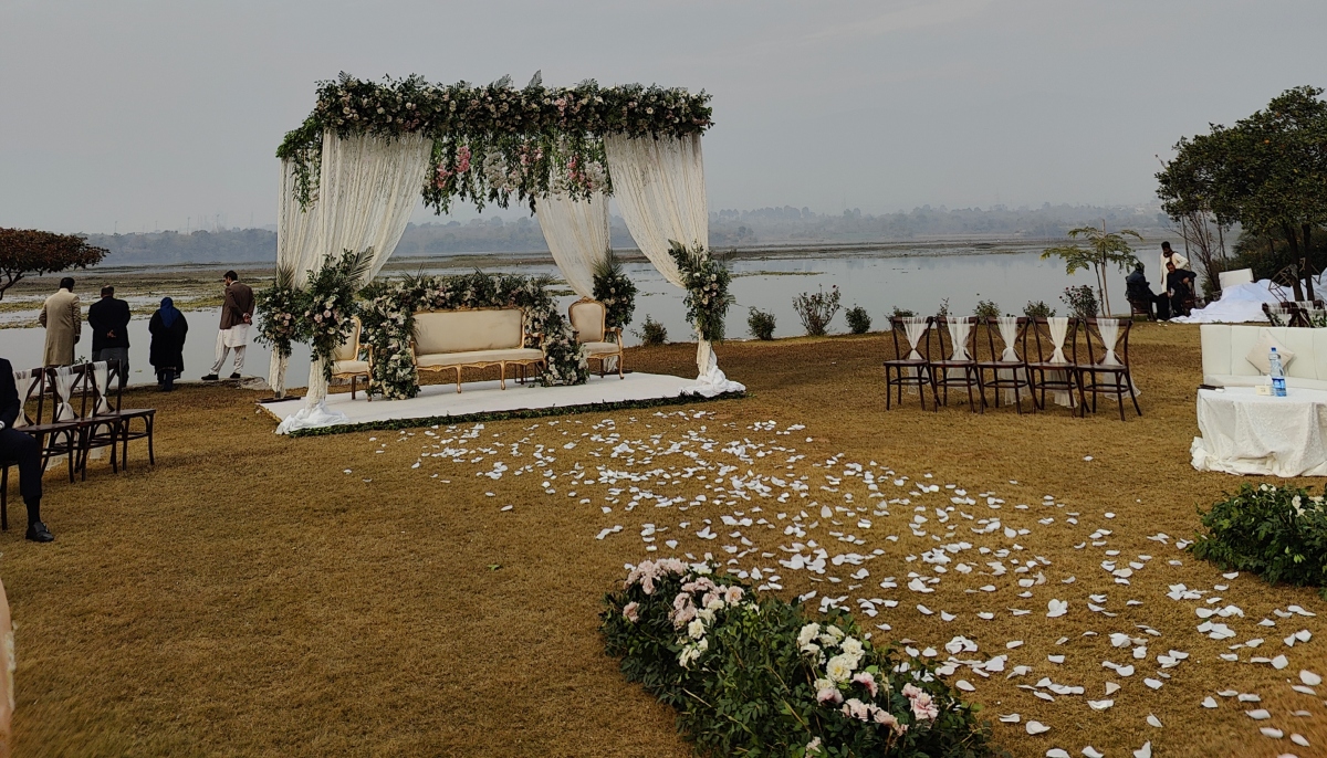 This photograph shows a wedding reception set-up by a river. — Photo by author