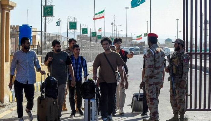This representational image shows Pakistani students evacuated from Iran walk across the Pakistan-Iran border at Taftan, in Balochistan province on June 18, 2025. — AFP