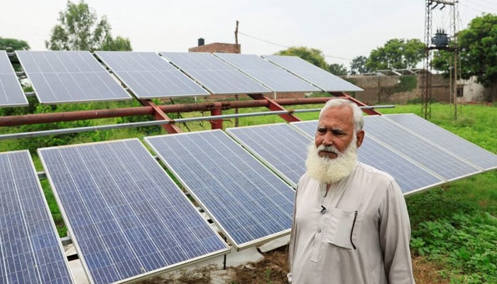A farmer, stands beside his solar panels, installed to run a tube well, the motorised pump that tap groundwater, amid a rice field, in Muridke, Sheikhupura District on August 12, 2025. — Reuters
