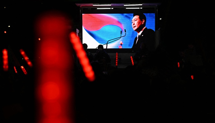 A large screen shows an image of impeached South Korea president Yoon Suk Yeol as light sticks held by his supporters are seen during a rally near his residence in Seoul on January 7, 2025. — AFP