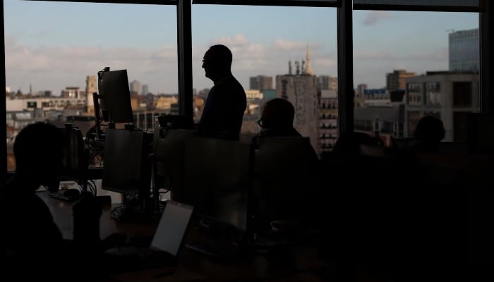 Employees work on computers in an office in London, Britain, November 13, 2025. — Reuters