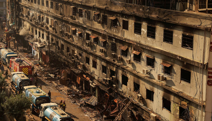 Fire department workers walk past the site, following a massive fire that broke out in the Gul Plaza Shopping Mall in Karachi, Pakistan, January 20, 2026. — Reuters
