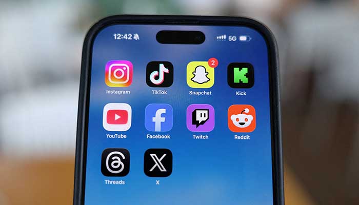 Instagram, TikTok, Snapchat, Kick, YouTube, Facebook, Twitch, Reddit, Threads and X applications are displayed on a mobile phone screen, in this picture illustration taken on December 9, 2025. — Reuters