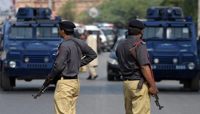 Karachi police personnel stand alert during a security operation. — AFP/File
