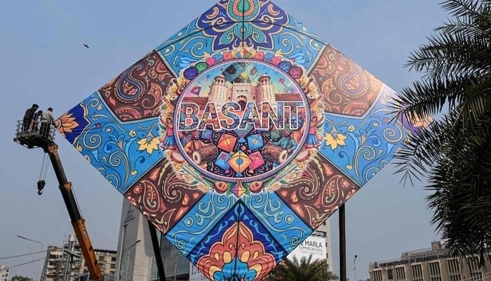 Workers install a large model of a kite celebrating the Basant festival in Lahore on February 3, 2026. — Reuters