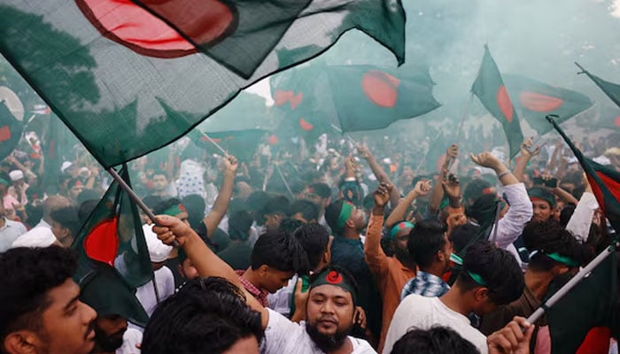 People wave flags during celebrations marking the one-year anniversary of student-led protests that led to the ousting of Bangladeshi then-Prime-Minister Sheikh Hasina, at Manik Mia Avenue, outside the parliament building, in Dhaka, Bangladesh, August 5, 2025.  — Reuters