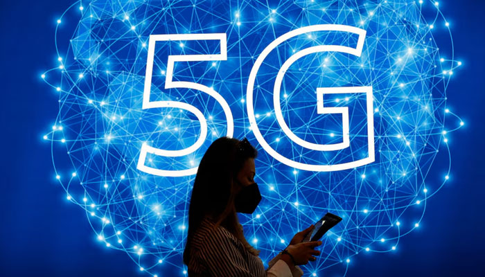 A woman walks past a 5G logo during GSMAs 2022 Mobile World Congress (MWC), in Barcelona, Spain, March 1, 2022. — Reuters