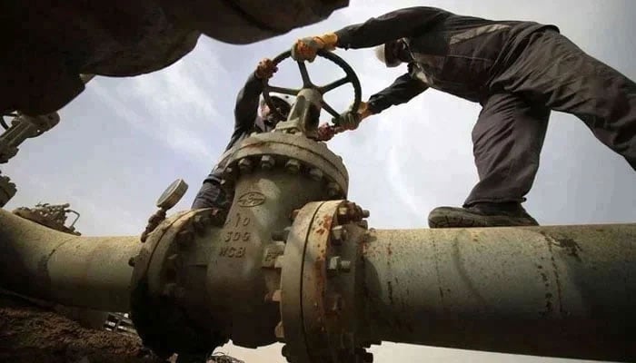 The representational image shows two employees working on a gas pipeline. — AFP/File