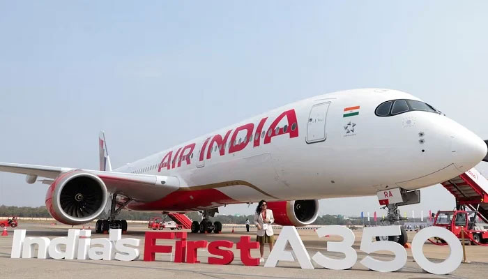 A woman stands next to the Air India Airbus A350 aeroplane, displayed at Wings India 2024 aviation event at Begumpet airport, Hyderabad, India on January 18, 2024. —Reuters