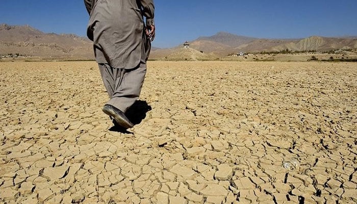 In this picture taken on October 6, 2018, a Pakistani villager walks on the cracks of the dry Hanna lake in Urak Valley, some 15 km from Quetta. — AFP