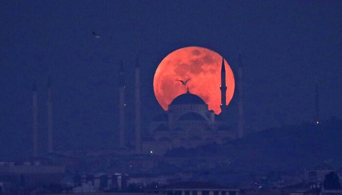 A full moon rises behind a mosque over the Camlica hill in Istanbul, Turkey. — Reuters