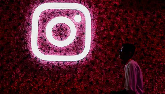 A representational image shows man walks past a logo of mobile application Instagram. — Reuters/File