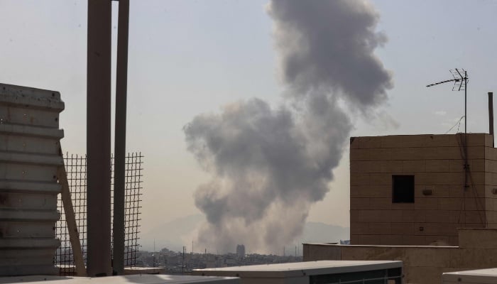 A plume of smoke rises following a reported explosion in Tehran on February 28, 2026. — AFP