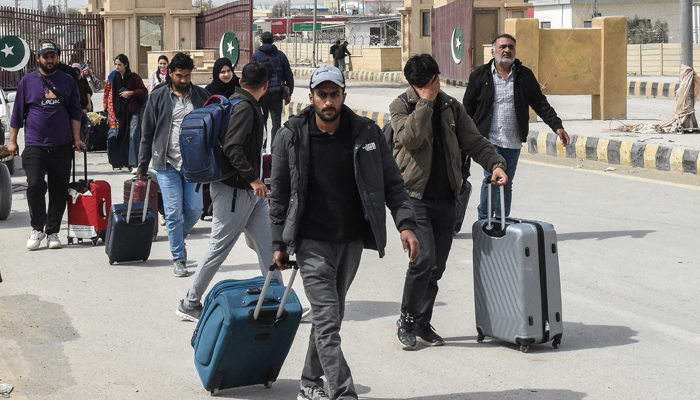 Pakistani nationals walk across the Pakistan-Iran border after returning from Iran at Taftan, Balochistan province on March 2, 2026 after the death of Irans supreme leader Ayatollah Ali Khamenei amid US-Israel strikes. — AFP