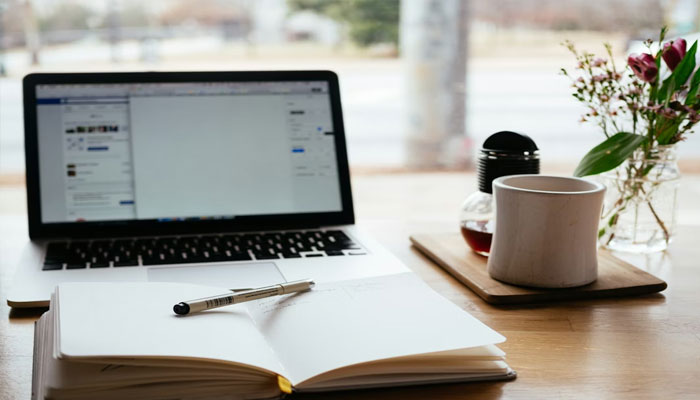 A representation of a laptop, notebook, and pen prepared for an online class. — Unsplash/File