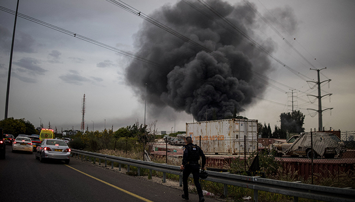 A policeman runs to an impact site following an Iranian missile strike, amid the US-Israeli war with Iran, in central Israel, March 13, 2026. — Reuters