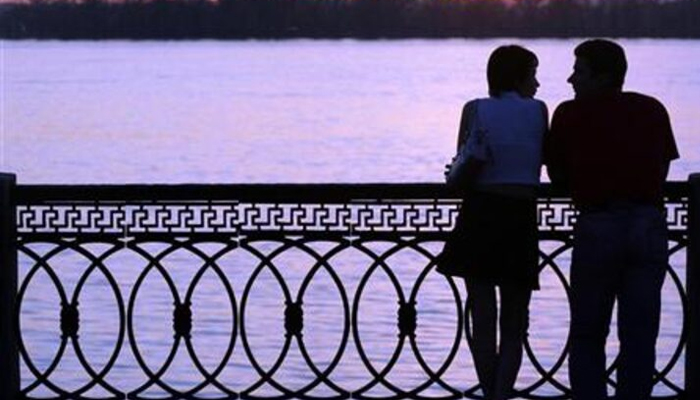 A couple stands at the embankment of a river. — Reuters/File