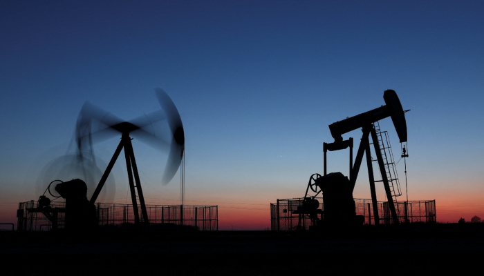 Oil pumps operate after sunset outside Vaudoy-en-Brie, near Paris, France, March 18, 2026. — Reuters