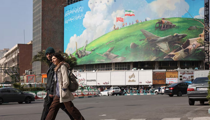 People walk past an anti-US billboard on a street in Tehran, Iran, February 5, 2026. — Reuters