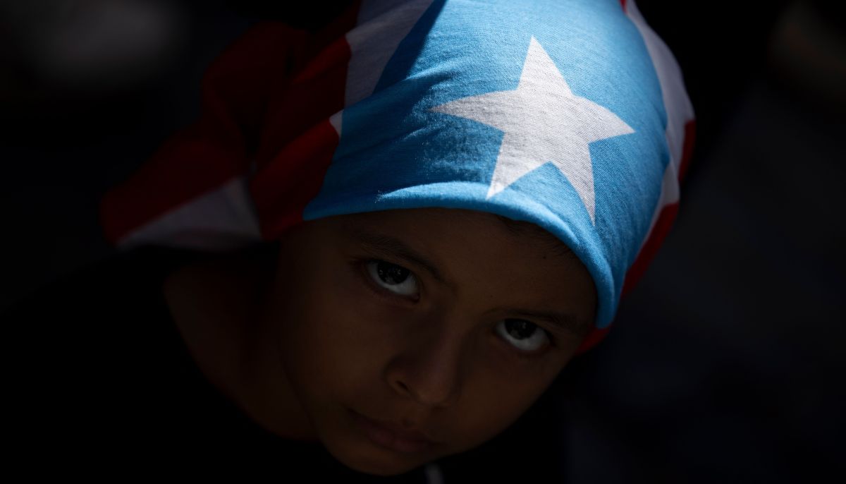 A child wearing a Puerto Rican flag looks on during the No Kings national day of protest that included opposition to the proposed Esencia coastal development project in San Juan, Puerto Rico, on March 28, 2026. — AFP