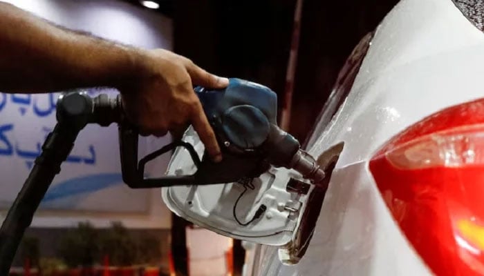 A worker holds a fuel nozzle to fill fuel in a car, after the government announced the increase of petrol and diesel prices, at a petrol station in Karachi, September 16, 2023.— Reuters