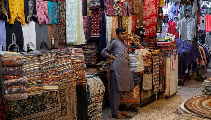 A shopkeeper stands outside his shop while waiting for customers, ahead of Eid al-Fitr celebrations in Karachi on April 19, 2023. — R