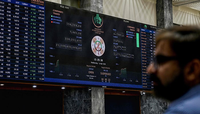 A stock broker looks at share prices on a digital board during a trading session at the Pakistan Stock Exchange (PSX) in Karachi on April 1, 2026. — AFP