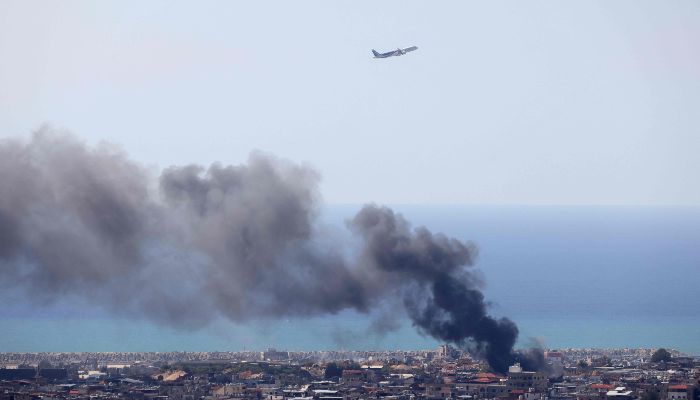 A Middle East Airlines aircraft takes off from the airport in Beirut as smoke rises from the site of an Israeli air strike that targeted an area in the southern suburbs of the Lebanese capital on March 17, 2026. — AFP