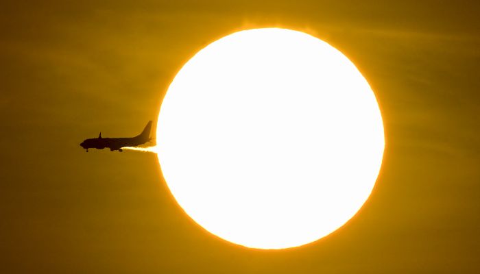 An airplane passes in front of the sun during sunrise in Panama City on April 15, 2026. — AFP
