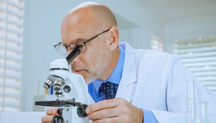 A man examining a microscope slide. — Pexels