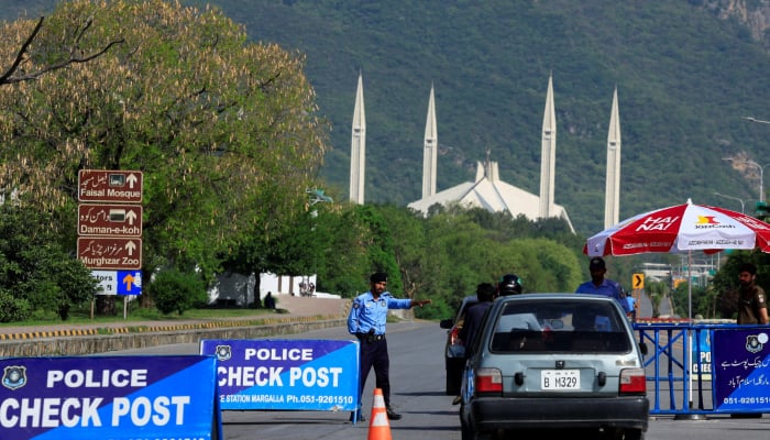 A police officer gestures to a vehicle at a check post along a road near Faisal Masjid, as Pakistan prepares to host the US and Iran for the potential second phase of peace talks in Islamabad, Pakistan April 19, 2026. — Reuters