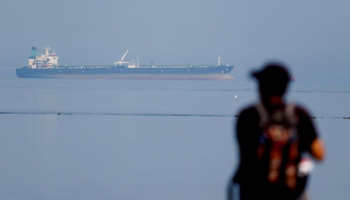 A tourist watches the MT Desert Kite oil tanker carrying Russian oil at Narara Marine National Park in the Arabian Sea, Gujarat, India, March 11, 2026. — Reuters
